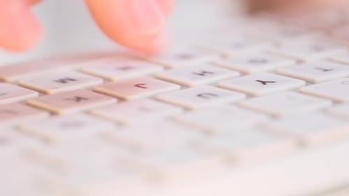 Hands Type Quickly on White Keyboard Conveying Productivity