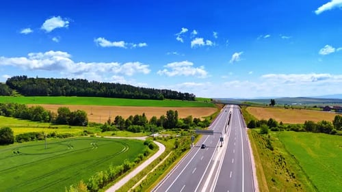 Open road through greenery. A highway runs through a vibrant green landscape under