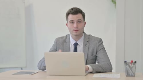Young Adult Man Gesturing Positively in Office