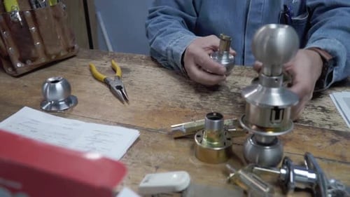 Latin man expert in lock repair service works concentrated at the table in his workshop. Mexico.