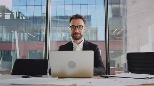 Man Working on Laptop in Office Smiling