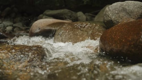 shallow depth of field focus rack wide angle of river water flowing rocks. slow motion videos.