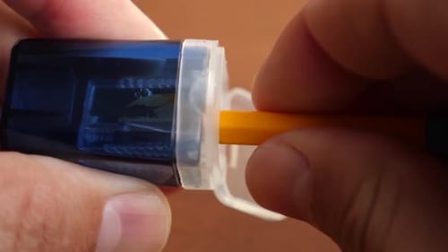 Sharpening a Yellow Pencil with a Navy Sharpener