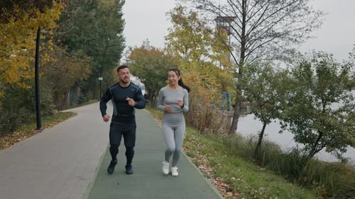 Joyful Couple Engage in Outdoor Jogging and Running A Sporting Duo Runs Together in the Park