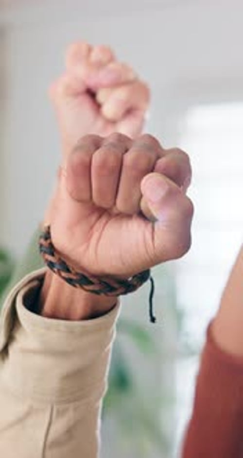 Diverse Group Raising Fists Together in Celebration