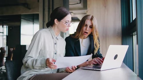 In a Vibrant Office Two Enthusiastic Professionals Collaborate on a Project Discussing and