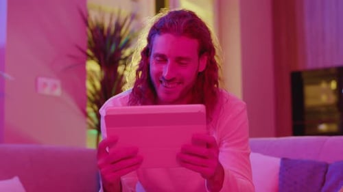 Man relaxing at home using tablet device