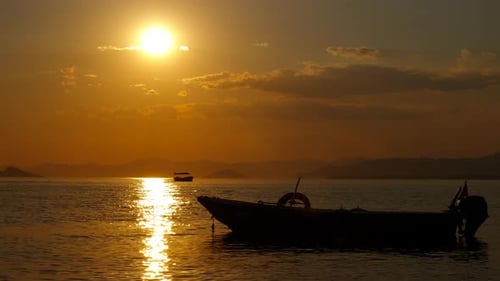 Beautiful golden sunset over ocean with boats silhouette