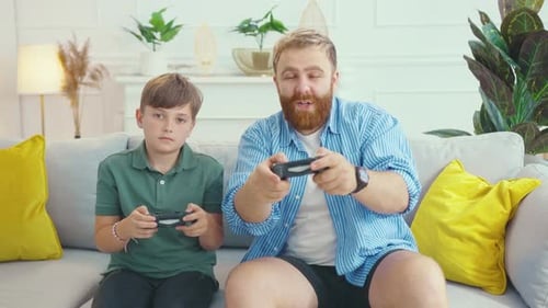Father and Son Playing Video Games on Couch