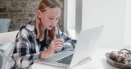 Teenager Working on Laptop at Home
