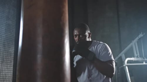 Fitness Workout in Gym Strong African Man Fighter Training Punches with Boxing Bag Healthy Boxer Man