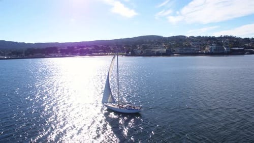 Sailboat glides across the azure waters of monterey bay California in stunning aerial view