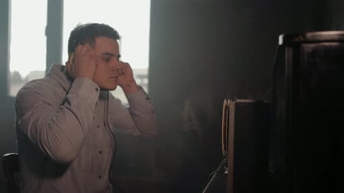 Man Adjusts Headphones at Vintage Television