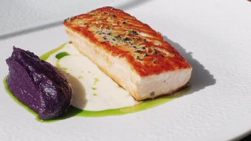 Grilled Salmon Steak with Sesame Seeds and Garnish in Modern Expensive Restaurant Close Up Shot of