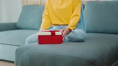 Young surprised muslim woman opening a gift
