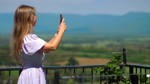 Woman Photographing Beautiful Landscape from Balcony