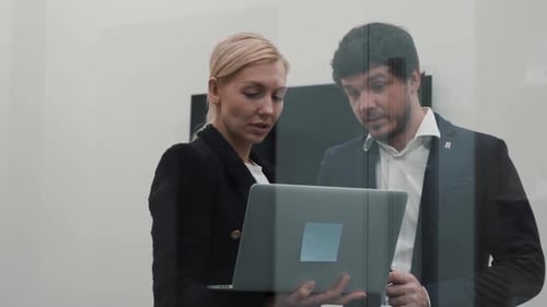 Colleagues Collaborate Using Laptop in Modern Workplace