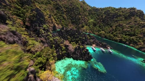 FPV-Drohnenflug über das türkisfarbene Meer und die Klippen in der Twin Lagoon Coron, Philippinen