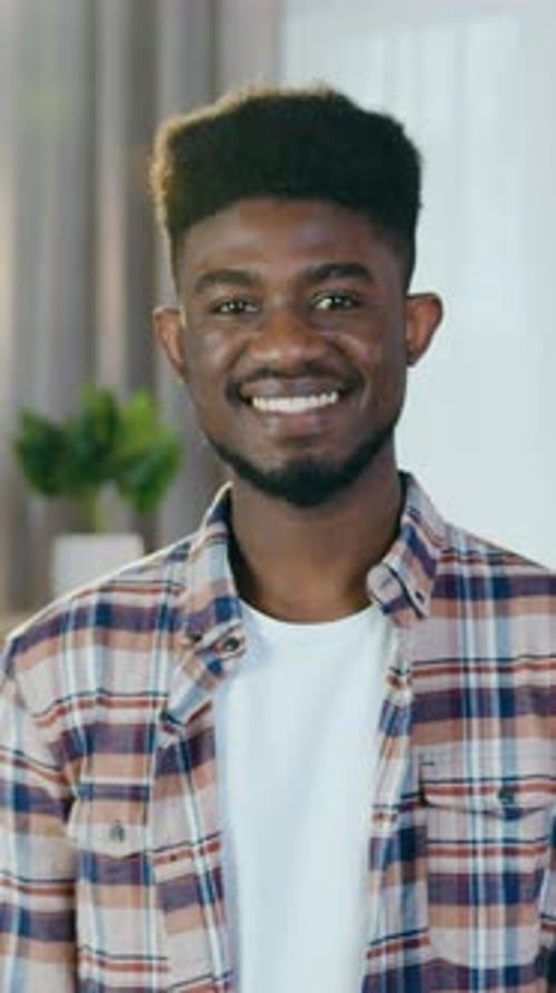 Close Up Portrait of Attractive African Man Which Posing on Camera at Workplace at Home