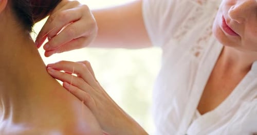 Acupuncteur caucasien traitant un patient métisse en clinique