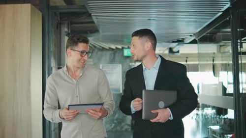 A Group of Businessmen in a Modern Office Corridor Engage in Brainstorming Discussing Ideas and