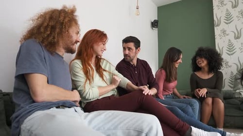 Friends Talking and Laughing Together on Sofa