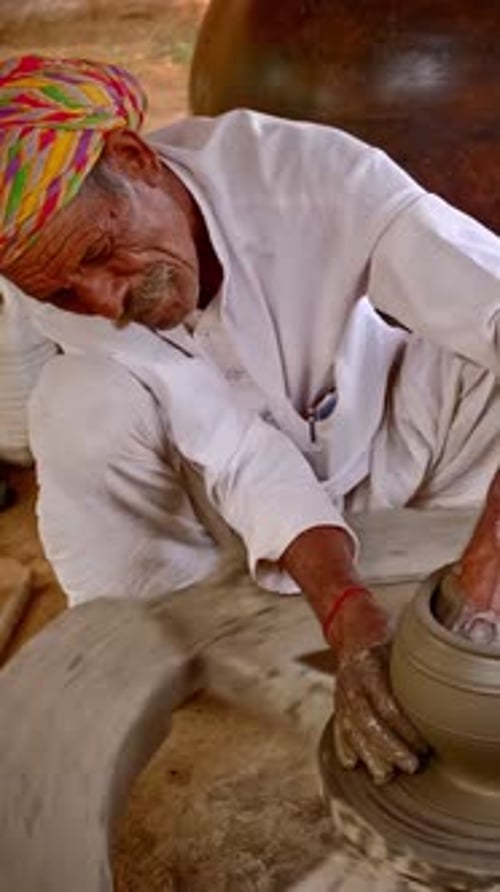 Potier indien au travail lançant un pot en argile façonnant un tour de potier dans un atelier de poterie du Rajasthan en Inde