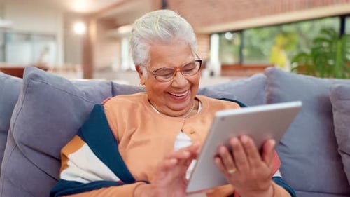Smiling Senior Woman Using Tablet on Couch