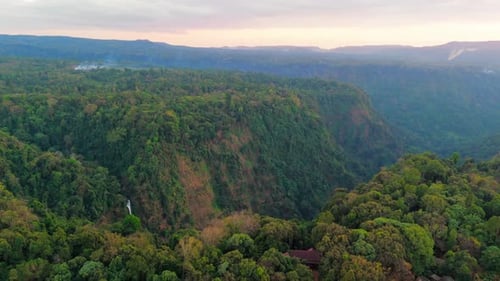 Drone aéreo ao pôr do sol do planalto de Pakse Bolaven, cachoeira mais alta do Laos, famoso circuito de motocicleta