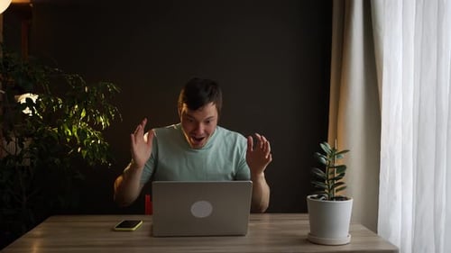 Young Adult Celebrates Success Working at Computer