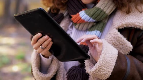 Woman Uses Tablet Outdoors in Nature