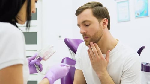 Man Consults with Dentist in Modern Office