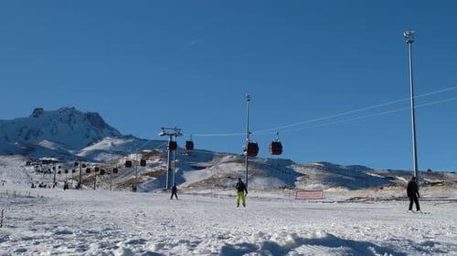 Timelapse of Skiers Sliding down from the top of the Ski Resort and the Working Cable Car