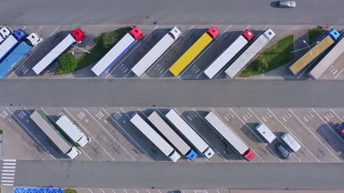 Highway parking with a lot of trucks and trailers rest area for truckers - aerial ascending shot