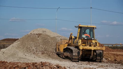 Bulldozer Parked next to Dirt Pile on Construction Site