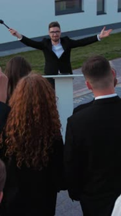 Auctioneer at a Podium Sells Something Outside