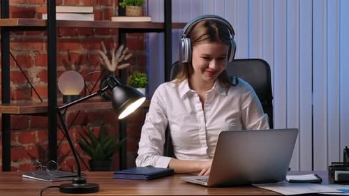 Woman in Headphones Video Calling at Desk