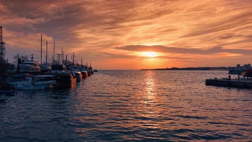 Setting sun in the overcast sky reflects in the rugged waterscape of the black Sea.