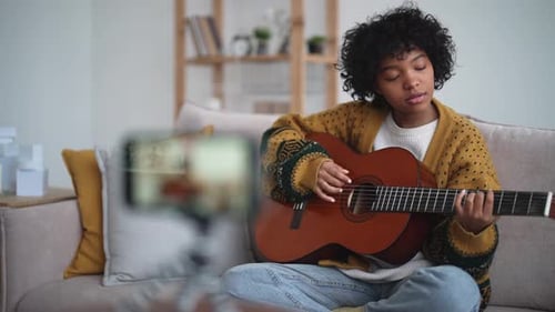 Young Adult Plays Guitar and Records Video