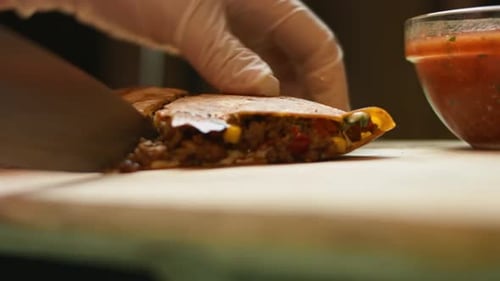 Cutting Stuffed Quesadilla on Wooden Cutting Board