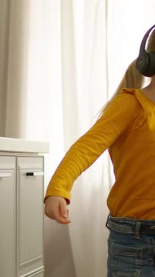 Girl with Headphones Dancing and Having Fun Indoors