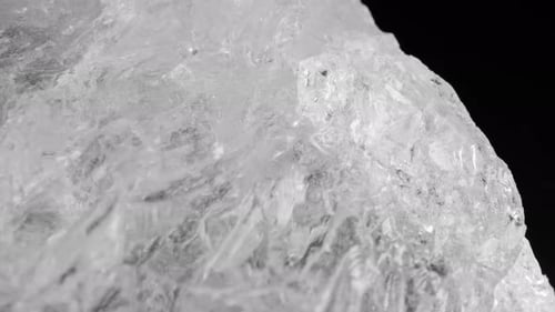 Cristaux de quartz blanc clair scintillant sur fond sombre, capturés grâce à une motorisation fluide