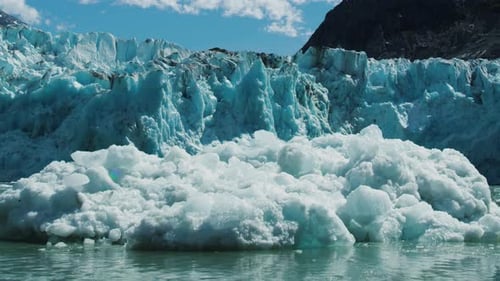 Glaciers calving. Ice cubes fall into the river forming numerous ice floes.