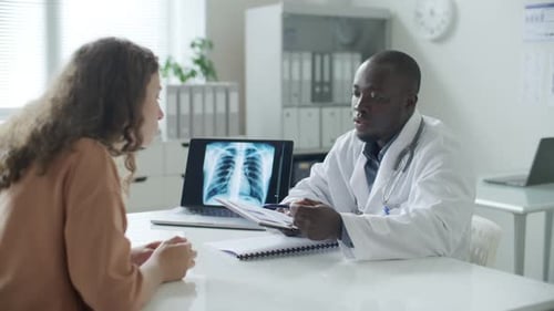 Doctor Discussing X-Ray Results with Patient in Office