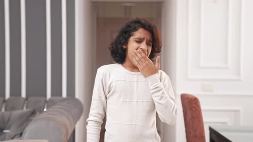 Tired Indian kid boy yawning and feeling sleepy