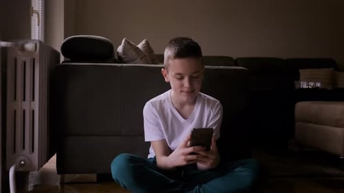 Teen Uses Phone While Sitting on Floor