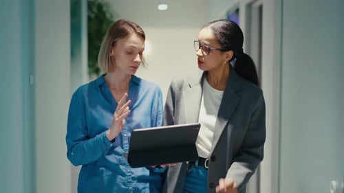 Professional Colleagues Discussing Work on a Tablet in a Modern Office