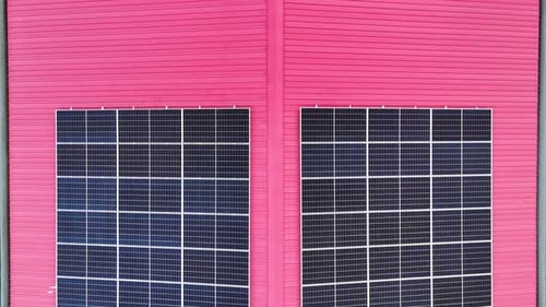 Aerial view of solar photo voltaic panels system on building roof. Renewable ecological green energy