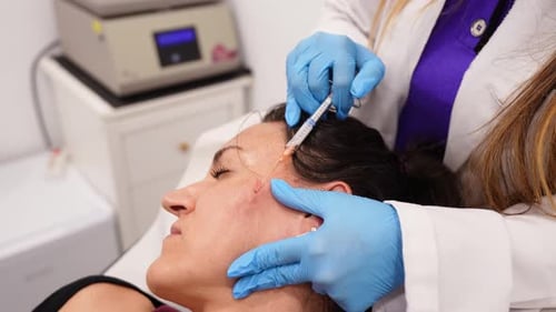 Woman receiving cosmetic medical procedure in office