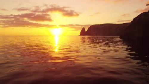 Aerial View on Sunset Over Calm Sea and Volcanic Rocky Shores